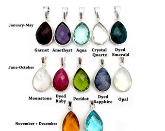 May include: Birthstone pendants in a teardrop shape with silver settings. The pendants are arranged in three rows, with each row representing a different month or months. The first row shows January-May, the second row shows June-October, and the third row shows November + December. The stones are: Garnet, Amethyst, Aqua, Crystal Quartz, Dyed Emerald, Moonstone, Dyed Ruby, Peridot, Dyed Sapphire, Opal, Citrine, and Blue Topaz.