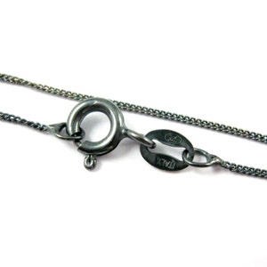 Puede incluir: Un collar de cadena de plata con un cierre de langosta y una etiqueta que dice "925 ITALY".