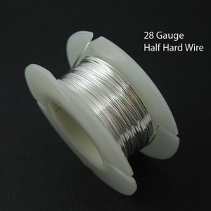 May include: A spool of silver-colored 28 gauge half hard wire. The wire is wound around a white plastic spool.