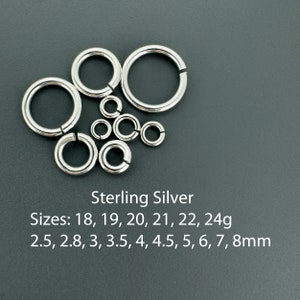 May include: Sterling silver jump rings in various sizes, ranging from 2.5 to 8 millimeters in diameter. The jump rings are arranged in a heart shape on a gray background. Sizes: 18, 19, 20, 21, 22, 24g. 2.5, 2.8, 3, 3.5, 4, 4.5, 5, 6, 7, 8mm.