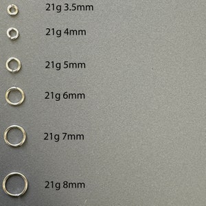 May include: Six silver hoop earrings in different sizes, ranging from 3.5mm to 8mm. Each hoop is labeled with its size in millimeters, for example, "21g 3.5mm".