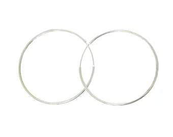 May include: A pair of silver hoop earrings. The hoops are simple and circular in shape.