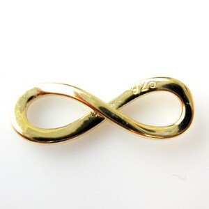 May include: Gold infinity symbol charm with the marking "925" on the back.