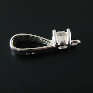 May include: Silver pendant with a clear round stone and a loop for attaching a chain.