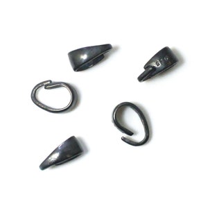May include: Four black metal pendant bails with a loop on one end and a flat, pointed end on the other. The bails are approximately 1 inch long.