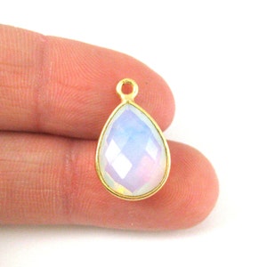 May include: Gold-plated pendant with a teardrop-shaped iridescent opal gemstone.