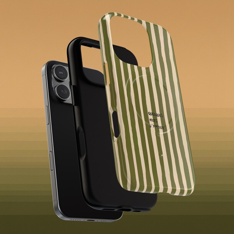 May include: A black smartphone with a black case and a green and white striped phone case. The phone case has the words "Quelques mots d'amour" printed on it.