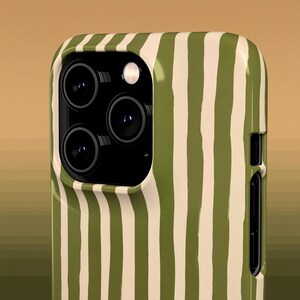May include: Close-up of a smartphone case with a green and off-white vertical stripe pattern. The case has a camera module with three lenses and a flash. The case is made of a glossy material.