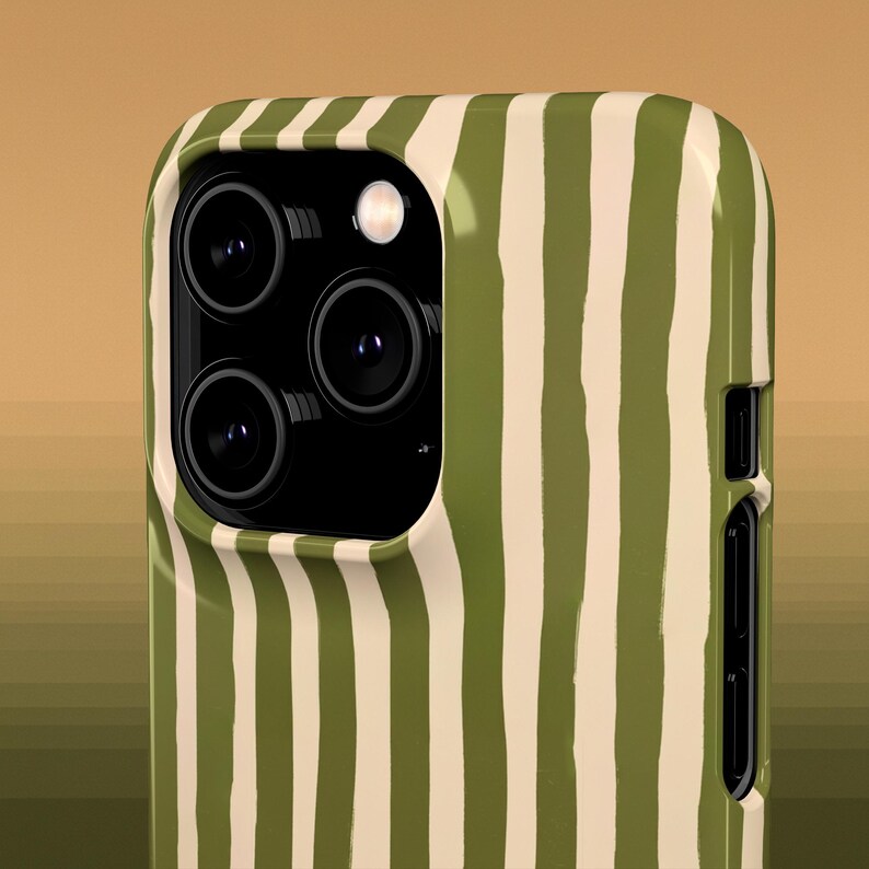 May include: Close-up of a smartphone case with a green and off-white vertical stripe pattern. The case has a camera module with three lenses and a flash. The case is made of a glossy material.
