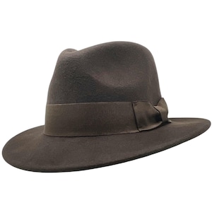 May include: A brown fedora hat with a wide brim and a matching ribbon band. The hat has a classic shape and is made of a soft material. This stylish hat is a versatile accessory for various outfits.