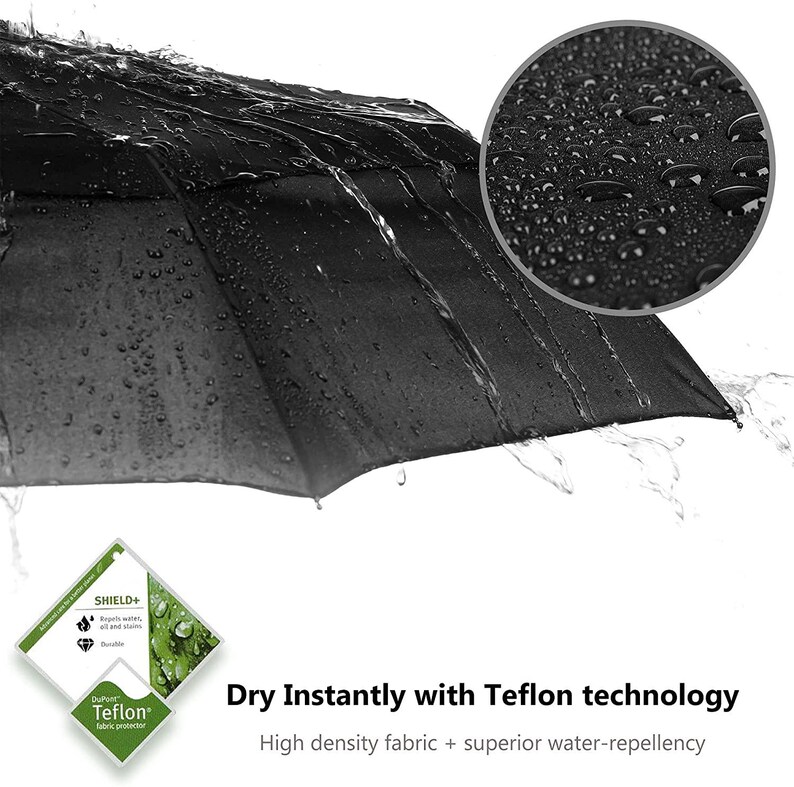 Peut inclure: Un parapluie noir avec des gouttelettes d'eau sur le tissu. Le parapluie est fabriqu&eacute; avec la technologie Teflon pour une imperm&eacute;abilit&eacute; sup&eacute;rieure. Le texte "SHIELD+" et "DuPont Teflon fabric protector" est visible sur l'image.