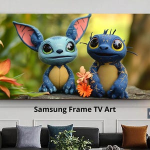 Peut inclure: Impression sur toile encadrée représentant deux créatures bleues fantaisistes aux grands yeux et au ventre jaune. L'œuvre comprend le texte "Samsung Frame TV Art" en bas. Les créatures sont placées sur un fond flou vert et orange.