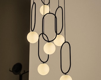 Lustre moderno de meados do século XX com formato elíptico preto - Luminária pendente contemporânea - Iluminação para escadas com pé-direito alto - Globo de vidro leitoso