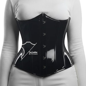 May include: A glossy black corset with a structured design. The corset features a pointed bustline, vertical seams, and button closures. The text "Top Leather Artisan" is visible on the side of the corset.