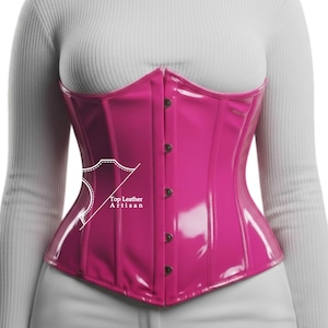 May include: A glossy, hot pink corset with a structured design. The corset features vertical panels, a pointed waist, and dark brown buttons. The text "Top Leather Artisan" is visible on the side.