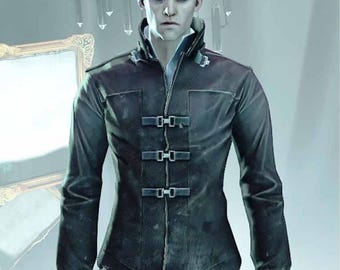 May include: A dark gray jacket with three buckle closures, a high collar, and long sleeves. The jacket is worn over a white collared shirt and paired with blue jeans. The image is a medium shot of a person.