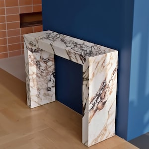 May include: A handcrafted wooden 'Welcome' sign in a playful font. The white-painted sign has a distressed finish and a floral design in pinks and greens. Suitable for indoor or outdoor display.