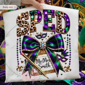 May include: White t-shirt with a colorful design featuring the word "SPED" in leopard print and jewel-toned letters. A large green and purple bow, a pencil, and the text "Mr/Mrs Smith" are also featured. The design includes Mardi Gras elements.
