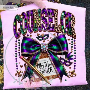 May include: A light pink t-shirt with the word "COUNSELOR" in a jeweled design. A large purple and green bow with a jeweled center is below the word. The shirt also features a pencil and the text "Mr/Mrs Smith".