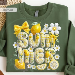 May include: Olive green sweatshirt with a decorative "SUMMER" design. The design features yellow lemons, daisies, and a yellow bow. The letters are embellished with a yellow and white checkered pattern and rhinestones.