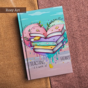 Op de afbeelding: Een notitieboek met een kleurrijke illustratie van boeken in de vorm van een hart. De kaft toont de tekst "TEACHING is a work of HEART" in een speels lettertype. Het ontwerp bevat pastelkleuren en bloemaccenten.
