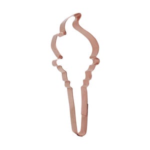 May include: A copper-colored metal cookie cutter shaped like a soft-serve ice cream cone. The outline features a rounded top representing the ice cream scoop and a narrow, tapered bottom section forming the cone, with a visible seam on the side.