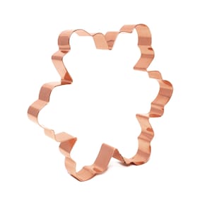 May include: A copper snowflake cookie cutter with a detailed, intricate design.