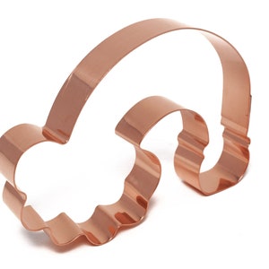 May include: A copper-coloured rainbow cookie cutter with a cloud shape at the bottom.
