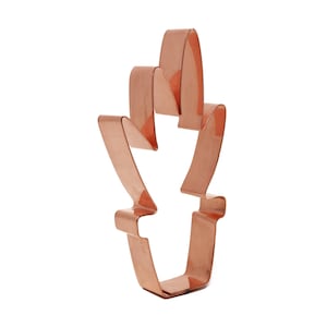 Może przedstawiać: Metalowa foremka do ciasteczek w kolorze miedzi w kształcie kolby kukurydzy z ostrym wierzchołkiem i zaokrąglonym dnem.