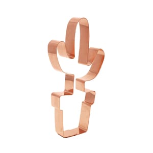 Może przedstawiać: Metalowa foremka do ciasteczek w kolorze miedzianym w kształcie kaktusa w doniczce. Foremka została zaprojektowana do wycinania ciasteczek w kształcie kaktusa.