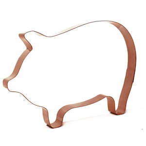May include: A copper-colored metal cookie cutter shaped like a pig. The cutter is designed to cut out cookies in the shape of a pig.
