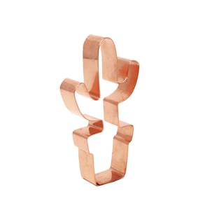 Może przedstawiać: Metalowa foremka do ciasteczek w kształcie kaktusa w doniczce, w kolorze miedzianym.