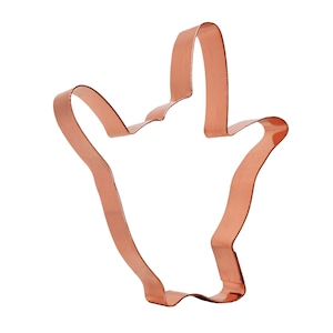 May include: Copper cookie cutter shaped like a hand giving the 'hang loose' sign.
