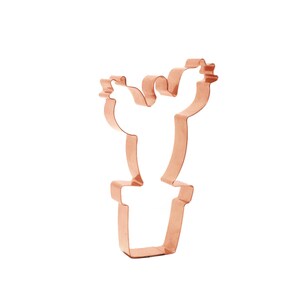 Może przedstawiać: Metalowa foremka do ciasteczek w kolorze miedzi w kształcie kaktusa w doniczce.