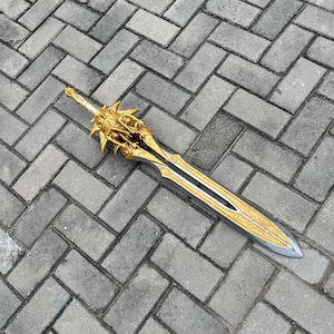 May include: A decorative sword with a gold and silver blade. The hilt and blade are intricately detailed with gold accents. The sword is approximately 40 inches long.