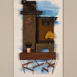 Può includere: Un'opera d'arte a tecnica mista raffigurante una struttura architettonica stilizzata. L'opera presenta una torre di legno con un quadrante dell'orologio, un piccolo albero e un elemento a forma di ponte, il tutto su uno sfondo di pennellate blu e bianche. L'opera è montata su una tavola rettangolare bianca.