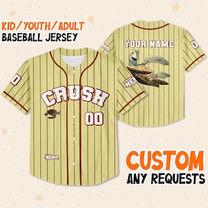 May include: A baseball jersey with a yellow and brown striped design. The front features the word "CRUSH" in white, the number "00", and a turtle graphic. The back has a turtle graphic and space for a name. Text on the jersey reads "KID/YOUTH/ADULT BASEBALL JERSEY".