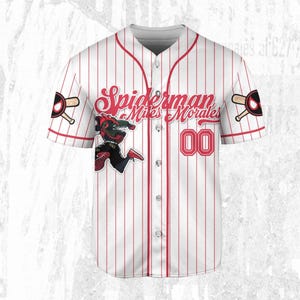 May include: White baseball jersey with red pinstripes, featuring the text "Spiderman Miles Morales" in red script. The jersey has the number "00" in red and a Spiderman graphic. Baseball bat and logo on the sleeves.