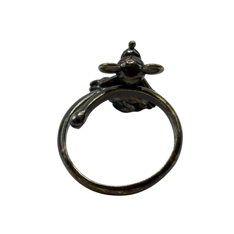 May include: A silver ring featuring a detailed design of a small bird with outstretched wings. The ring is open and has a smooth, rounded band.