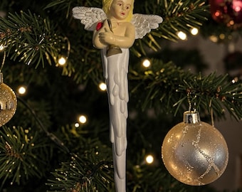Adorno navideño de plástico con forma de ángel carámbano sosteniendo una campana, de estilo antiguo.