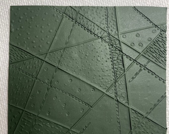 May include: A dark green textured sheet of paper with a geometric pattern of lines and circles. The paper has a rough, embossed texture.