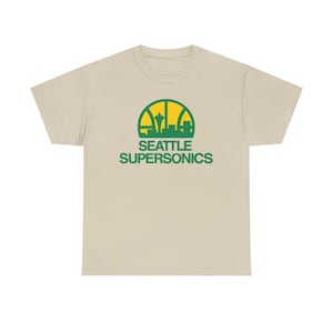 May include: A beige t-shirt featuring a green and yellow graphic of the Seattle skyline and the words "SEATTLE SUPERSONICS" in green. The design is centered on the front of the shirt.