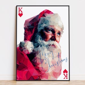 May include: Framed art print featuring a low-poly illustration of Santa Claus. The image is predominantly red and white, with blue accents. The text "Merry Christmas" is written in a cursive font. The artwork includes the King of Hearts playing card symbol.