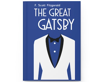 May include: A hardcover book with a blue cover featuring the title "THE GREAT GATSBY" in white, with the author's name, F. Scott Fitzgerald, above. The cover design includes a white tuxedo jacket with a black bow tie.