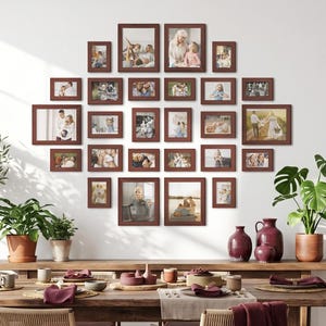 Puede incluir: Una composición de pared de galería con veinticuatro marcos de fotos de madera marrón oscuro que contienen varias fotografías, dispuestos sobre una mesa de comedor de madera larga con cuatro sillas, dos plantas y dos jarrones de cerámica roja.