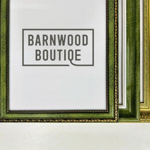 Może przedstawiać: Zbliżenie trzech dekoracyjnych ramek do zdjęć. Przednia ramka jest ciemnozielona ze złotym obramowaniem i tekstem "BARNWOOD BOUTIQUE". Pozostałe dwie ramki są zielone i złote z ozdobnymi detalami.