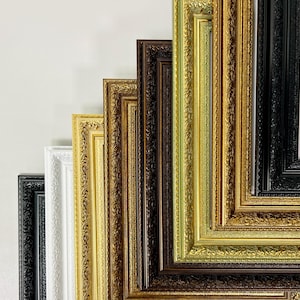 Könnte beinhalten: Eine Sammlung verzierter Bilderrahmen in verschiedenen Farben, darunter Schwarz, Weiß, Gold und Braun. Die Rahmen haben detaillierte, strukturierte Designs und sind diagonal angeordnet, um ihre verschiedenen Stile und Oberflächen hervorzuheben.