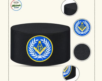 May include: Black cap with a circular emblem featuring a gold 'G' inside a square and compass design, surrounded by a laurel wreath on a blue background. The cap has the text "Masonic Trend" on the upper left corner.