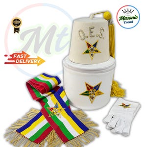 May include: A cream-colored O.E.S. fez hat with rhinestone accents and a gold tassel, paired with a matching white container. Also includes a colorful sash with gold fringe and white gloves, all featuring star emblems.