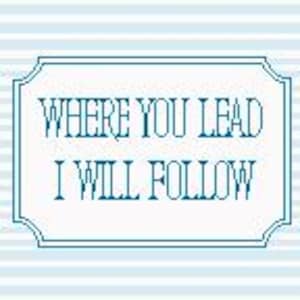 May include: A rectangular sign with the text "WHERE YOU LEAD I WILL FOLLOW" in a teal font, framed by a teal border. The background features light blue and white horizontal stripes.